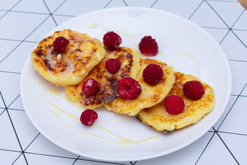 Tasty curd cakes with condensed milk and raspberries