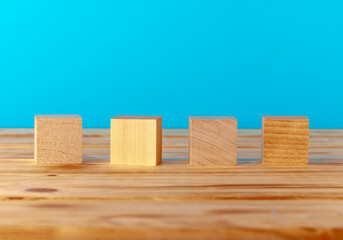Stacked wooden blocks on wooden desk against blue background