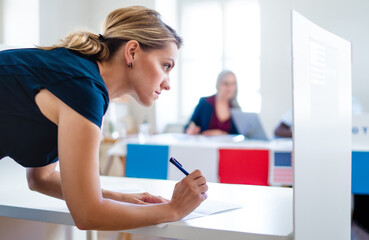 Portrait of woman voter in polling place, usa elections concept.