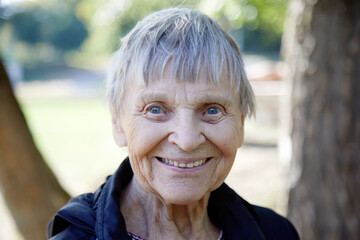 Portrait of ninety year old woman is smiling in the park.