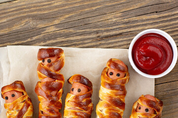 Scary sausage mummies in dough for kids party. Funny crazy Halloween food for children.