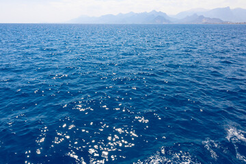 beautiful bright blue sea and sky with the mountains in the horizon