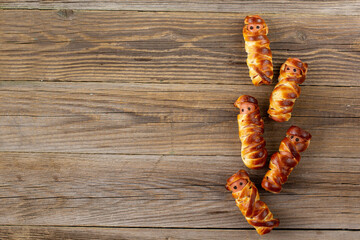 Scary sausage mummies in dough for kids party. Funny crazy Halloween food for children.