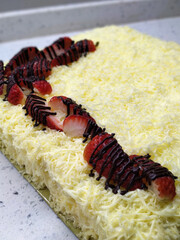 Selected focused on the chocolate & cheese cake. Rectangular in shape. Has been cut into small cubes to make it easier to eat.