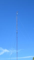 Foto de una torre muy alta para comunicaci&oacute;n, sostenida por cables.
