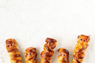 Scary sausage mummies in dough for kids party. Funny crazy Halloween food for children.