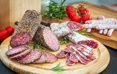 Assorted sliced italian salami on wooden plate