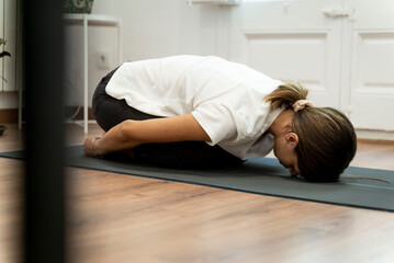 Fototapeta na wymiar Young girl doing yoga in her living room.