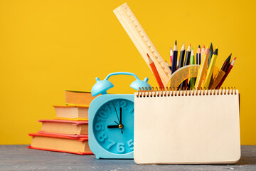 Back to school concept with alarm clock