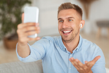 Happy guy using mobile phone for video call