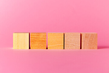 Toy wooden cubes with copy space against pink background