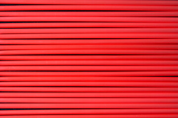 Top view of red  plastic drinking straws in a row. 