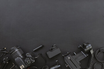 top view of work space photographer with digital camera and accessory on black background with copy space. flat lay