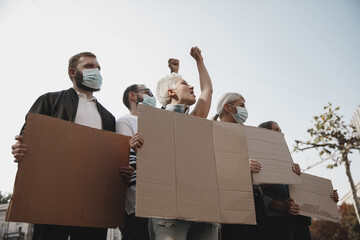 Human rights. Group of activists giving slogans in a rally. Caucasian men and women marching...