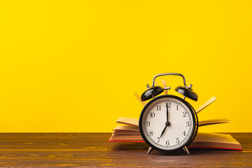 Books and alarm clock on table, education concept