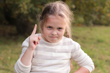 Closeup portrait angry, mad child disguised as boss, executive businessman, pointing finger at someone, displeased, isolated green background. Human face expressions, emotions, feelings, body language