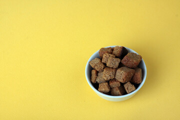 a bowl of dentels isolated on yellow background flat lay