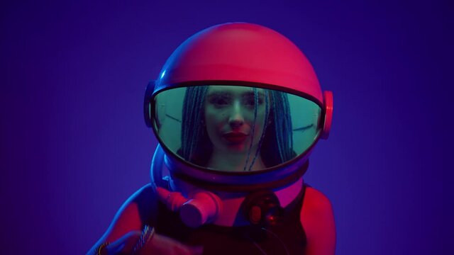 Woman in space helmet. Multi-colored neon lighting.