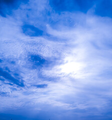 White clouds under the rays of the bright sun against the blue sky. Baku. 09/27/2020.