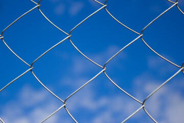 View of the blue sky through the steel netting.