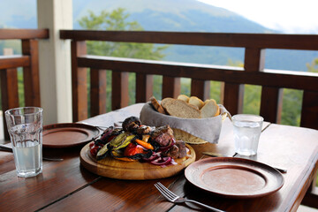 Kebab. Grilled meat and bread basket. Grilled vegetables with meat. Dinner. Food day. Fried meat with grilled vegetables. Tasty food. Table with food. Lunch is on the table. Carpathian cuisine
