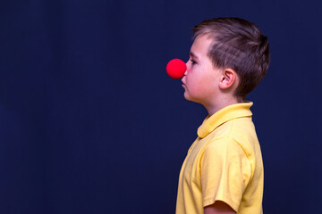 Side view Portrait of child boy wearing clown nose,red nose concept.