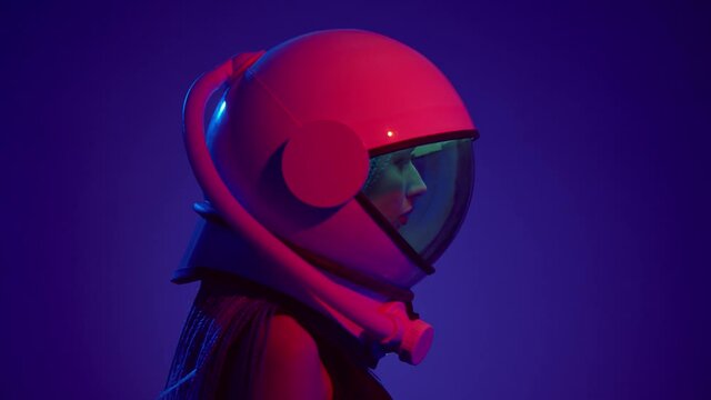 Woman in space helmet. Multi-colored neon lighting.