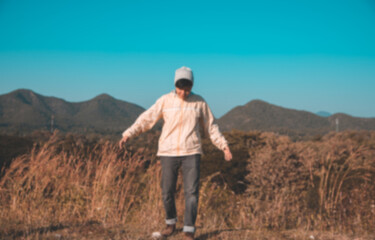 Fototapeta na wymiar Blur fun Asian young man in Long-sleeved shirt and grey hat hiking standing at mountain peak above clouds Hiker outdoor. Maetip Reservoir Lamphun Province, Northern Thailand Province in the morning.