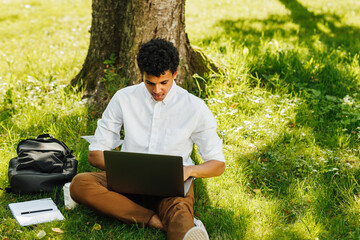 High angle view of a freelancer working on a laptop in park