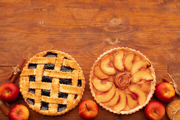 Thanksgiving berry and apple various pies on wooden surface, top view
