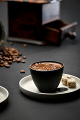 Traditional Turkish coffee served with Turkish delight over black background 