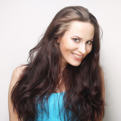 smiling brunette woman over grey background
