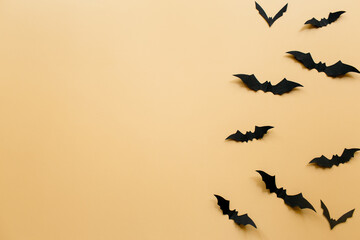 Halloween decorations with bats on pastel beige background. Halloween concept. Flat lay, top view, copy space