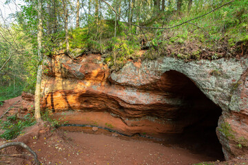 A beautiful  ochre cave in the forest in early autumn.
