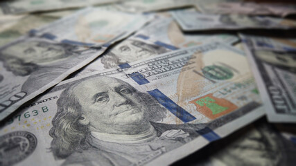 Hundred dollar Ben franklin bills in pile for business and financial concept.  American US dollar federal reserve background texture.  Cash and prosperity for economic impact and financial abundance.
