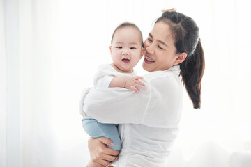 Happy asian mother playing with newborn baby. Closeup portrait of beautiful young mom and her son infant. Healthcare and medical family love lifestyle asia mother’s day concept