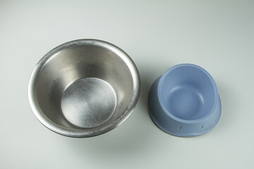 two bowls for animals one in steel and one blue in plastic one for cat and one for dog empty