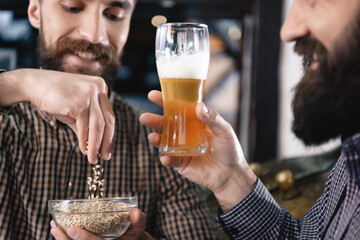 Man holds a glass of beer in his hands. 