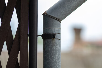 Old rusty gutter close-up against the sky. With a blurred background.