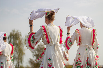 Girls in folk Russian dresses. Introduction of the folklore group on the stage. 