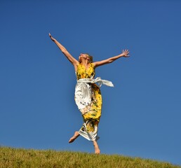 Woman jumping in a blue sky