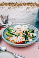 Healthy Breakfast with poached eggs, roasted red pepper, tenderstem broccoli, asparagus, romesco sauce, olives, toasted almonds and feta cheese