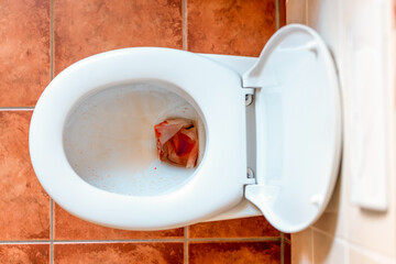 weiße mit Blut befleckte Keramik-Toilettenschüssel – mögliche Folgen von Menstruation,...