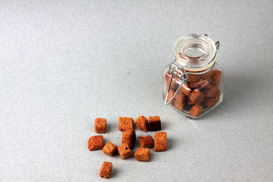 a glass can of dentels and a pile of dentils isolated on gray background