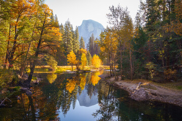 Yosemite Valley river with reflection of Half-Dome and autumn trees