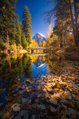 Yosemite Valley river with reflection of Half-Dome and autumn trees