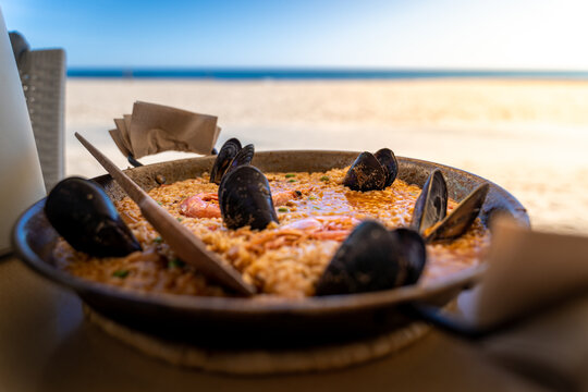 Seafood paella in seaside restaurant. Selective focus. Mediterranean village of Torredembarra in Costa Dorada, Tarragona, Spain