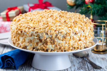 Carrot cake decorated with cream cheese frosting and walnuts, Christmas decoration on background, horizontal
