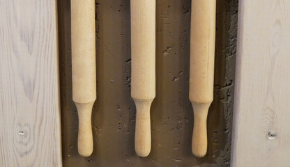 Rolling pins for rolling dough whist on the wall, as a decor for the institution. Cafe interior, food and ecology concept.
