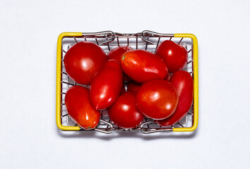 Shot of tomatoes in shopping basket on white background. Ripe tasty red tomatos in shopping basket. Top view